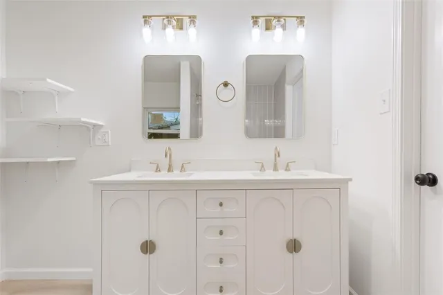 a bathroom with double sink and two mirror
