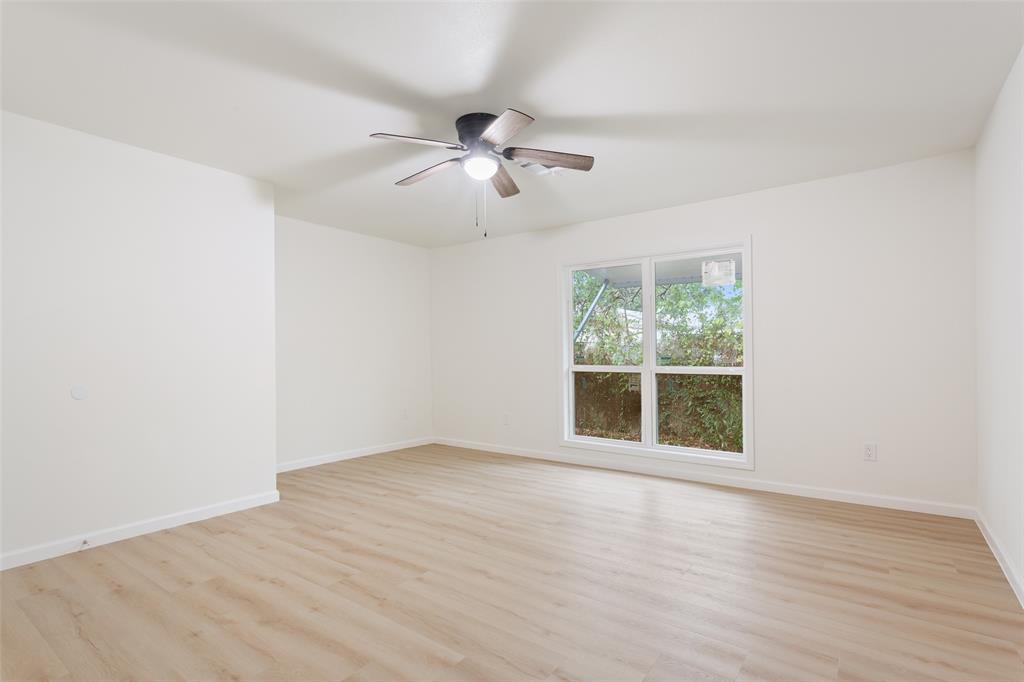 1029 North 45th Street Waco, TX 76710 - Photo 25 of 35 an empty room with wooden floor ceiling fan and windows