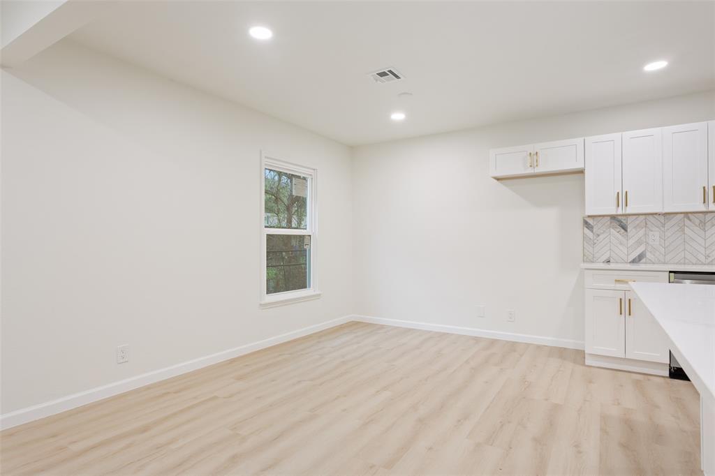 1029 North 45th Street Waco, TX 76710 - Photo 10 of 35 a view of a kitchen with a sink and dishwasher a stove top oven with wooden floor