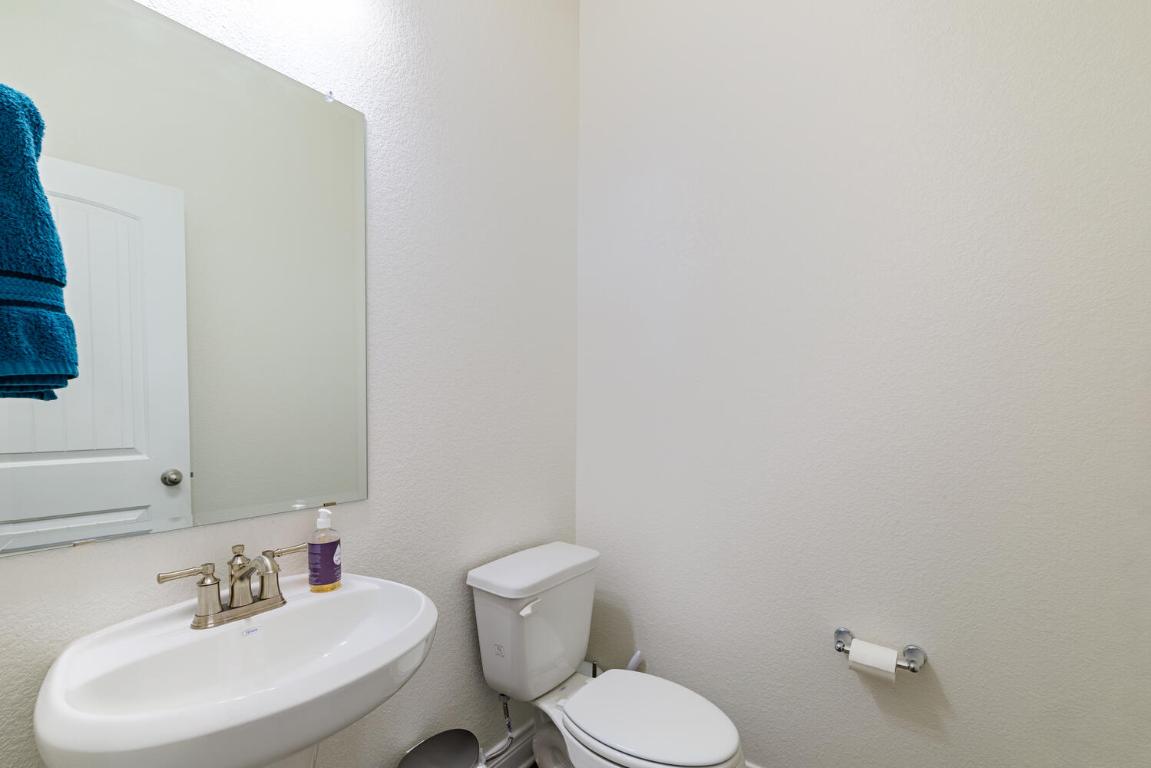 4641 Alfano Loop Round Rock, TX 78665 - Photo 15 of 32 a bathroom with a toilet sink and mirror