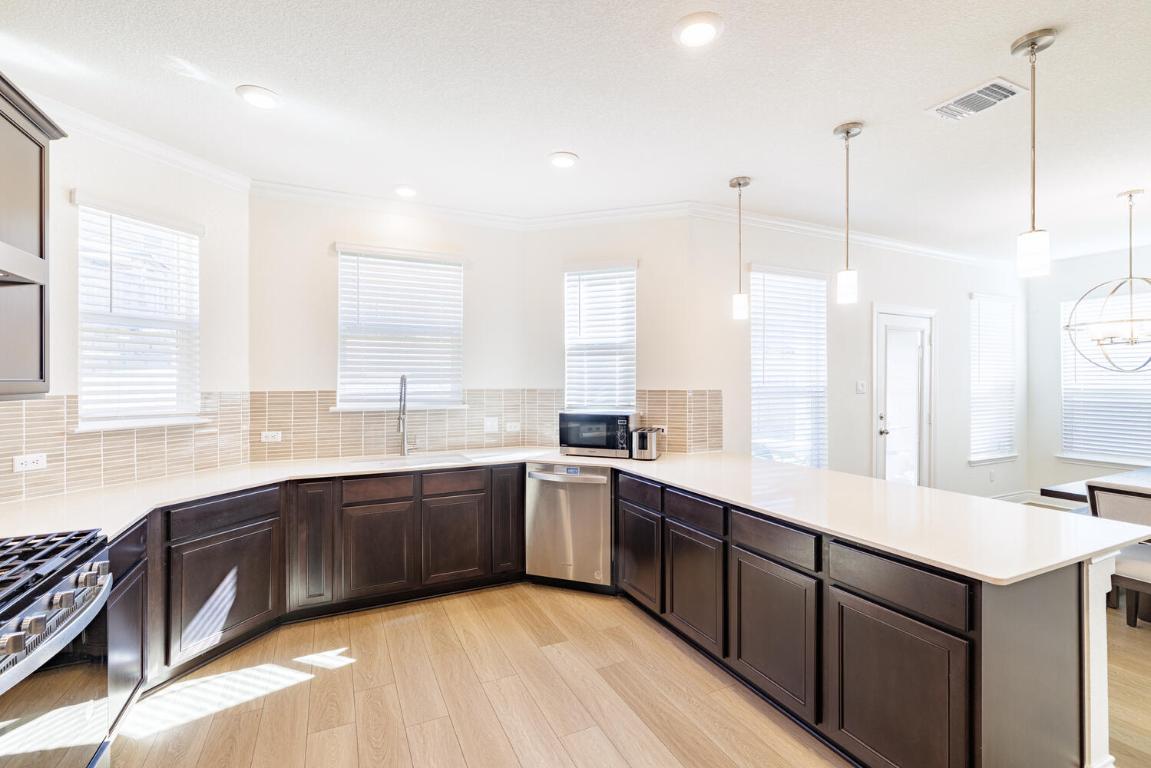 4641 Alfano Loop Round Rock, TX 78665 - Photo 9 of 32 a large kitchen with a large window and stainless steel appliances