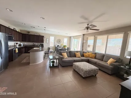 a kitchen with stainless steel appliances granite countertop a sink a stove a refrigerator cabinets and chairs