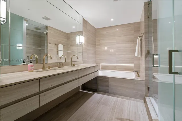 a bathroom with a double vanity sink a mirror and a bathtub