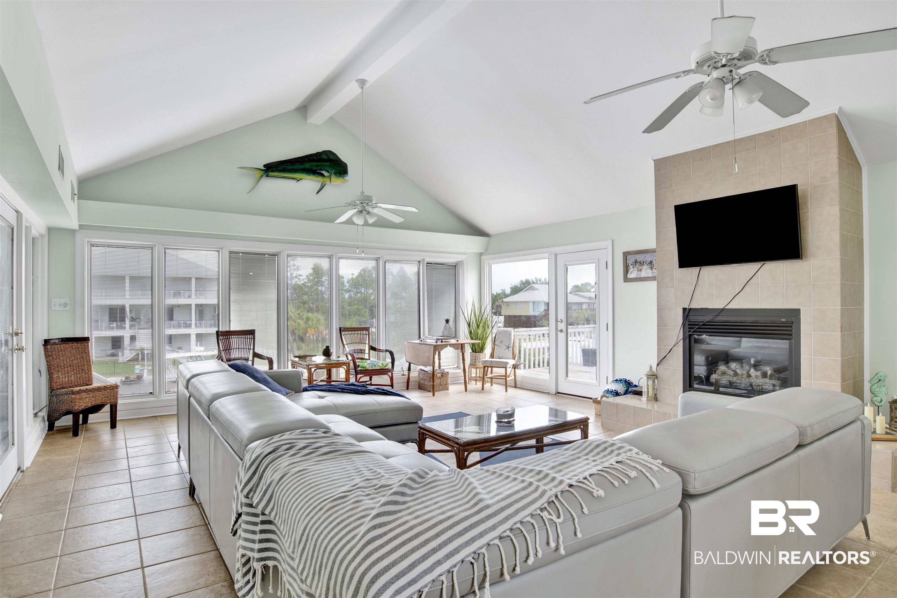 33093 River Road Orange Beach, AL 36561 - Photo 4 of 30 Tiled living room featuring beam ceiling, a tile fireplace, high vaulted ceiling, and ceiling fan