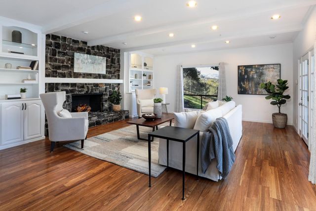 a living room with furniture fireplace and wooden floor