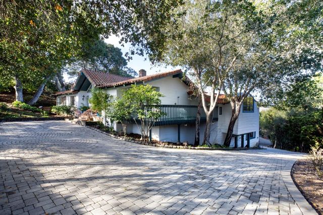 a view of a house with a tree and wooden fence