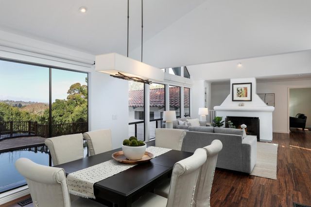 a living room with furniture large window and wooden floor