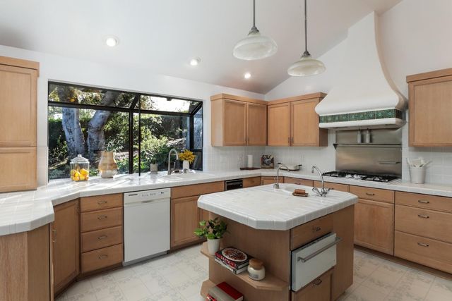 a kitchen with a stove sink and cabinets