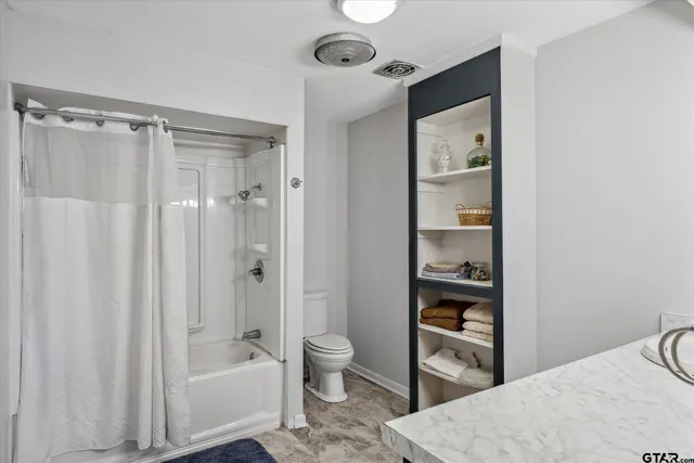 a bathroom with a bathtub shower sink vanity and toilet