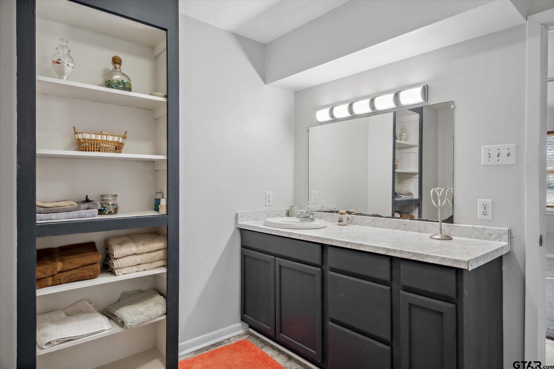 542 South Houston Street Edgewood, TX 75117 - Photo 18 of 37 a bathroom with a granite countertop sink and a mirror