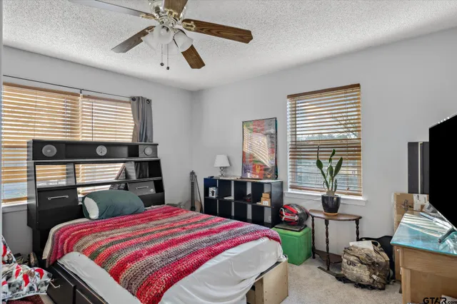 a bedroom with a bed and a large window with the outer view