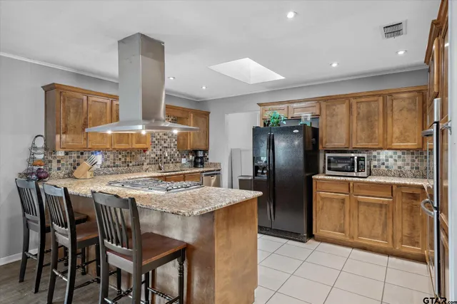 a kitchen with stainless steel appliances granite countertop a stove refrigerator sink and cabinets