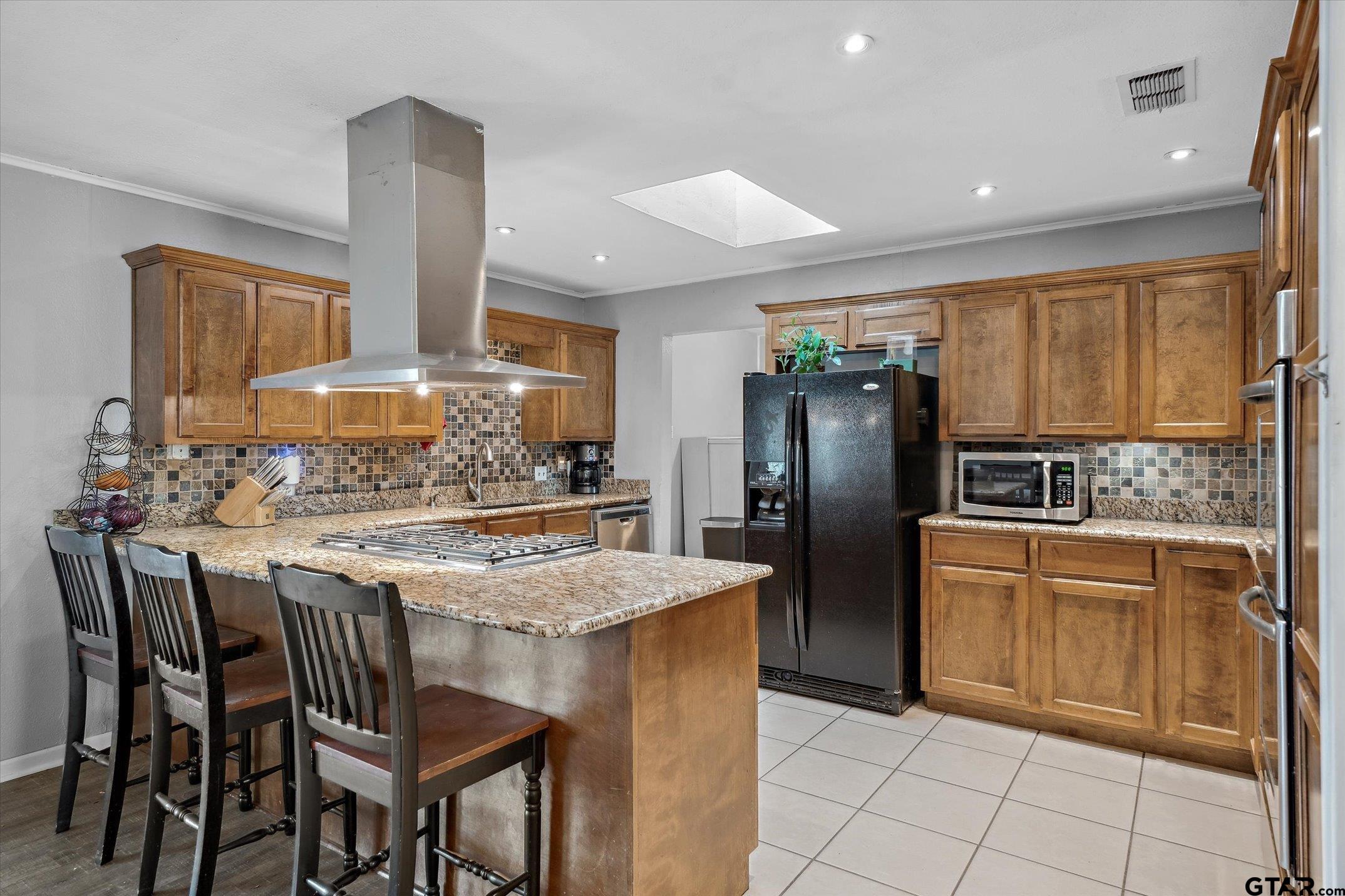 542 South Houston Street Edgewood, TX 75117 - Photo 25 of 37 a kitchen with stainless steel appliances granite countertop a stove refrigerator sink and cabinets