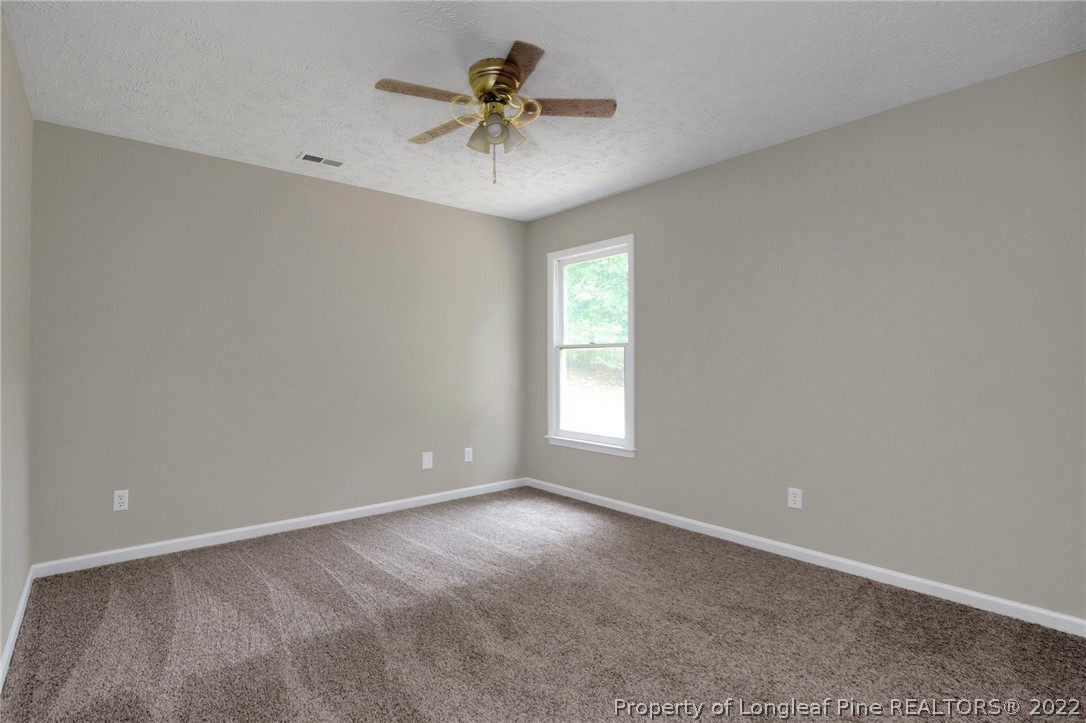 512 Andover Road Fayetteville, NC 28311 - Photo 13 of 18 an empty room with a chandelier fan and windows