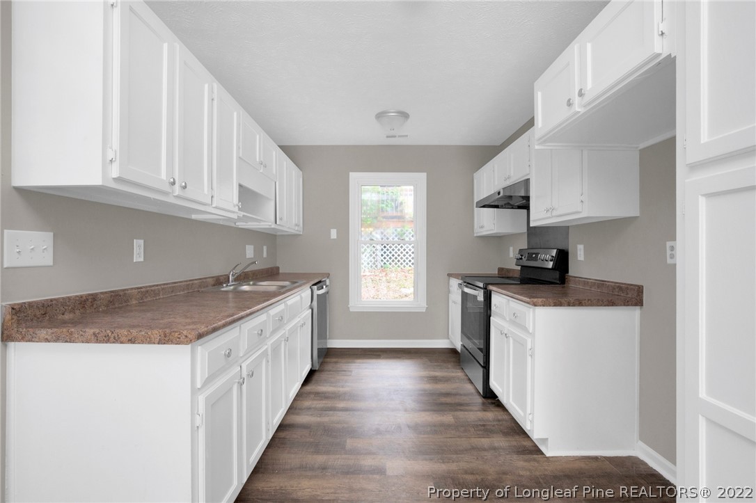 512 Andover Road Fayetteville, NC 28311 - Photo 7 of 18 a kitchen with granite countertop a sink stove and cabinets