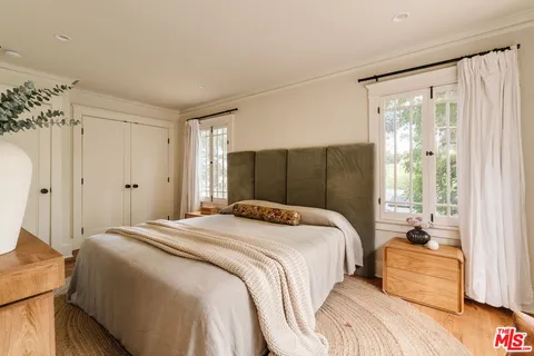 a bedroom with a bed and a large mirror