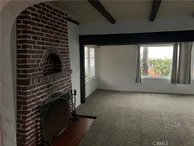 a view of empty room with windows and fireplace