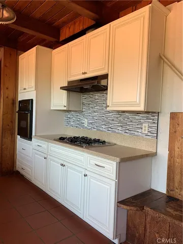 a kitchen with granite countertop a sink a stove and cabinets