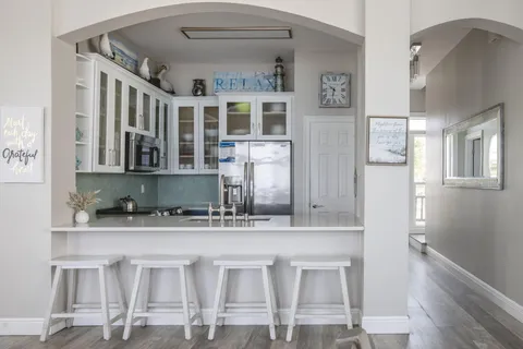 a kitchen with stainless steel appliances kitchen island granite countertop a dining table chairs and cabinets