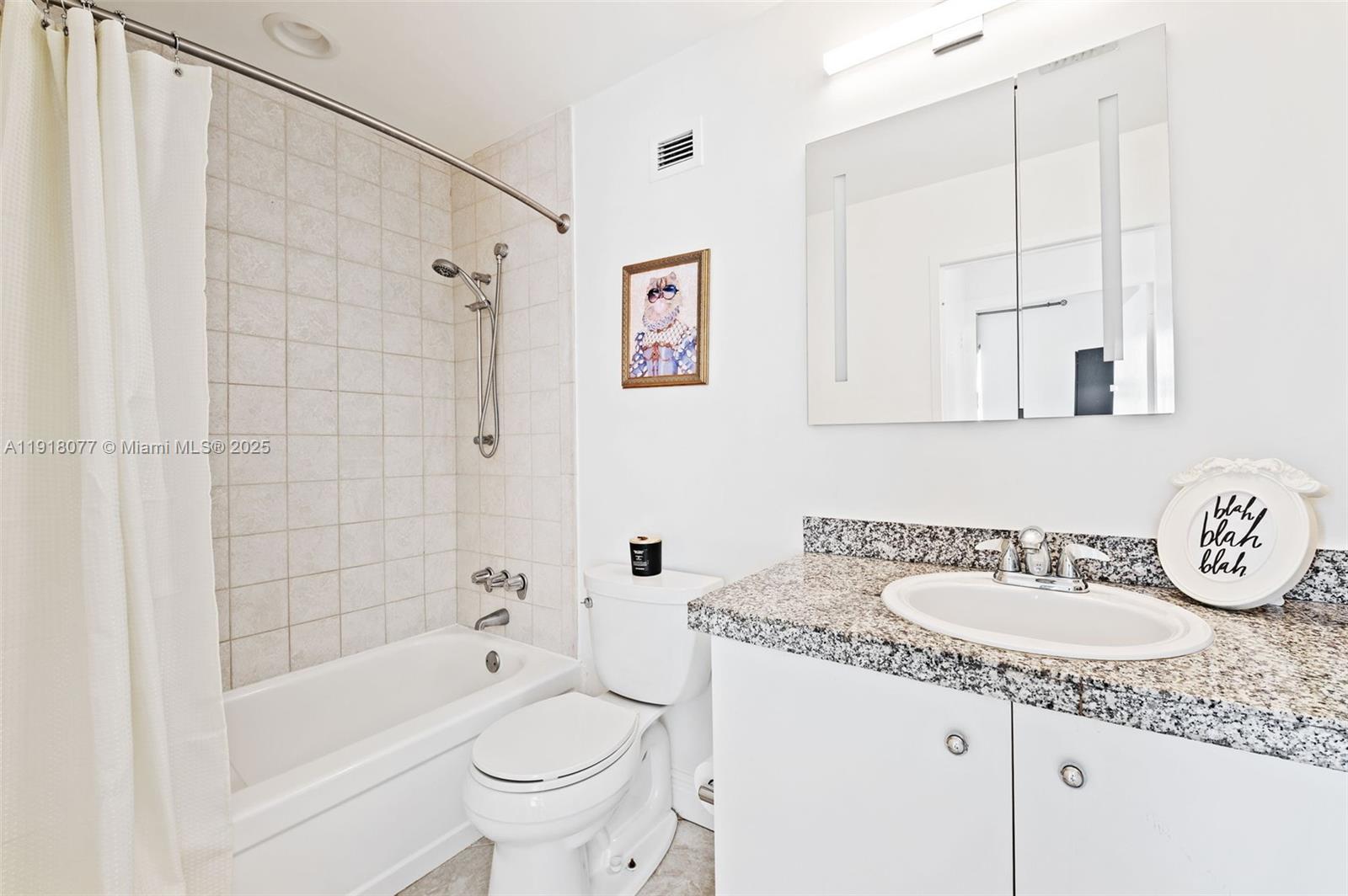 9195 Collins Avenue, Unit PH14 Surfside, FL 33154 - Photo 12 of 26 a bathroom with a granite countertop sink a toilet and bathtub