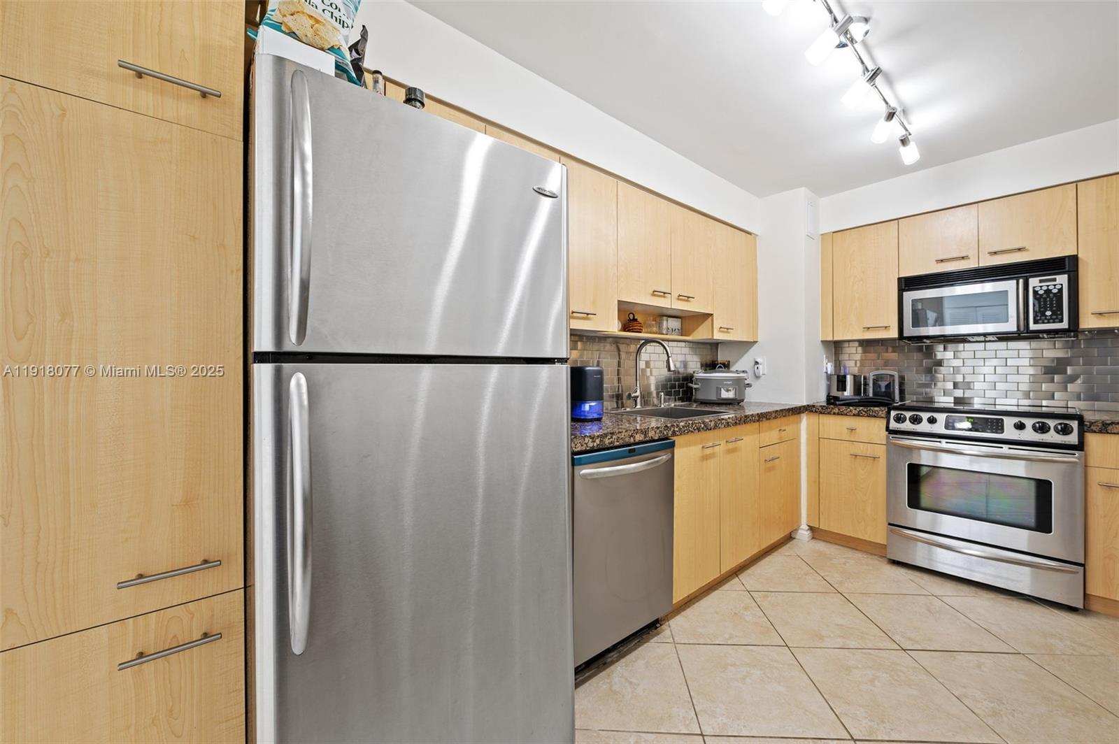 9195 Collins Avenue, Unit PH14 Surfside, FL 33154 - Photo 6 of 26 a kitchen with cabinets a refrigerator and a stove