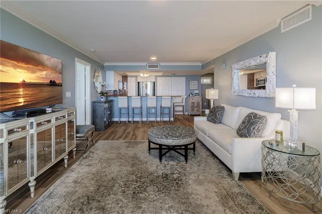 a kitchen with stainless steel appliances wooden floor dining table chairs and wooden floor
