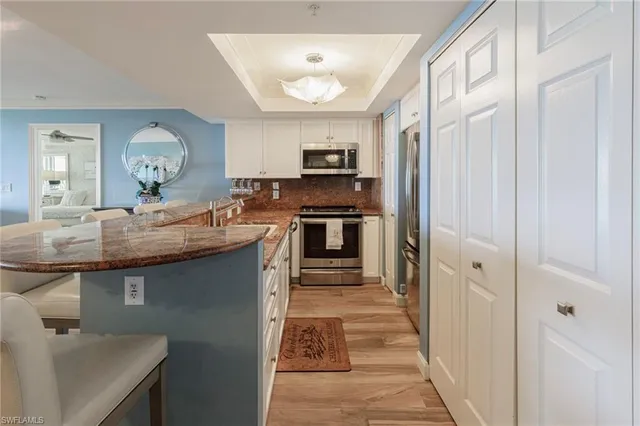 a kitchen with kitchen island granite countertop a sink cabinets and stainless steel appliances