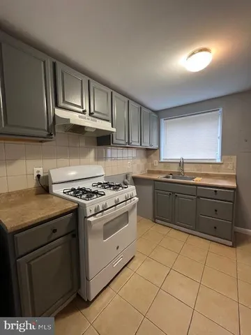 a kitchen with stainless steel appliances a stove sink and cabinets