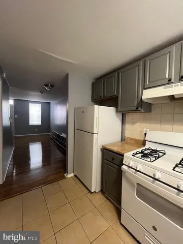 a kitchen with granite countertop a refrigerator stove and cabinets