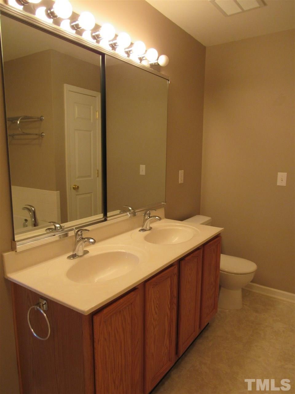 8620 Neuse Landing Lane, Unit 101 Raleigh, NC 27616 - Photo 12 of 16 a bathroom with a sink and a mirror