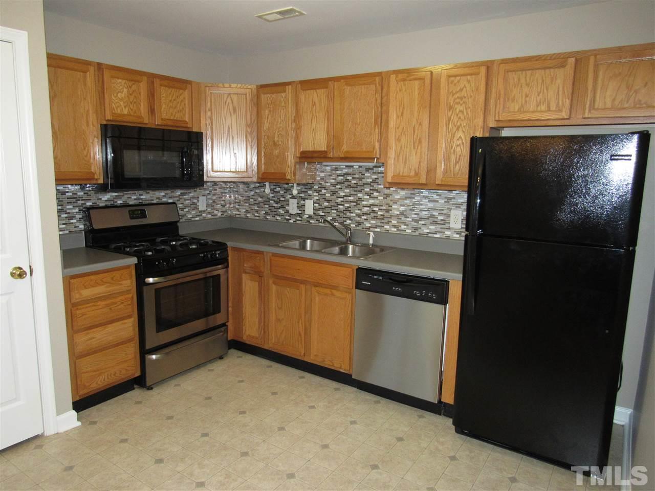 8620 Neuse Landing Lane, Unit 101 Raleigh, NC 27616 - Photo 2 of 16 a kitchen with a sink stove and refrigerator