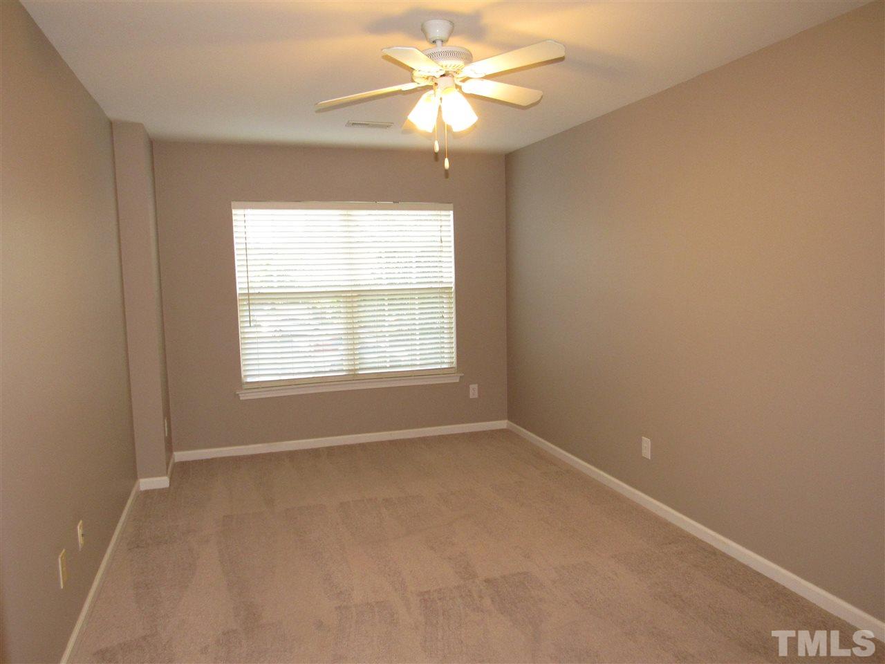 8620 Neuse Landing Lane, Unit 101 Raleigh, NC 27616 - Photo 9 of 16 an empty room with a window and a fan