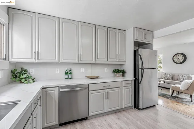 a kitchen with a refrigerator sink and cabinets