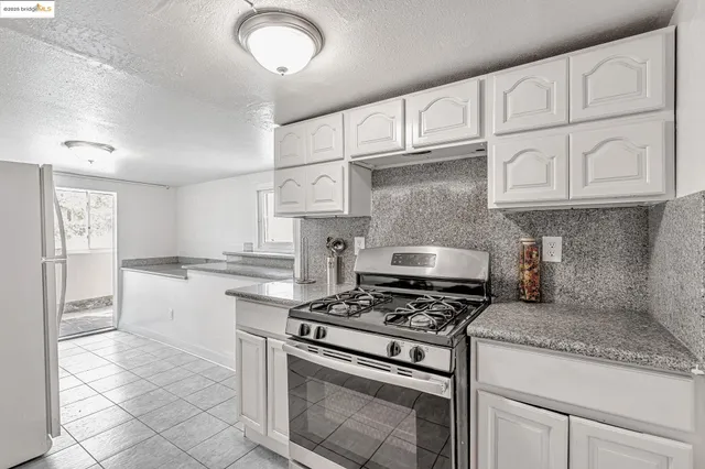 a kitchen with granite countertop a stove sink and cabinets