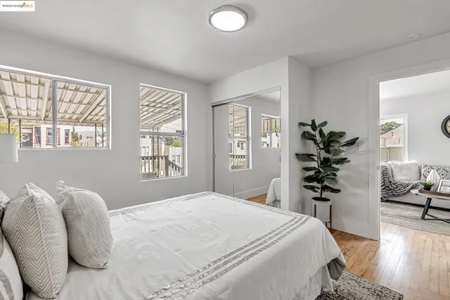 a bedroom with a large bed and wooden floor