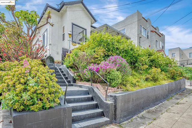 a front view of a house with a yard and flowers