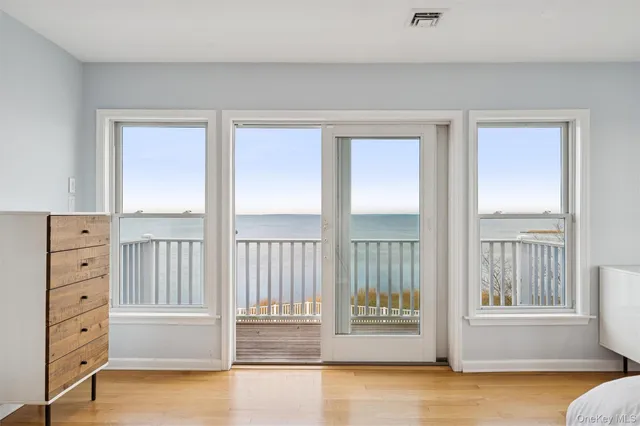 a view of a bedroom with a bed and wooden floor
