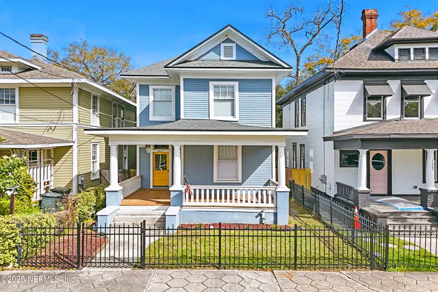 a front view of a house with a iron fence