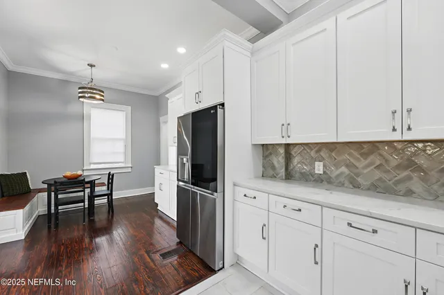 a kitchen with granite countertop white cabinets and stainless steel appliances