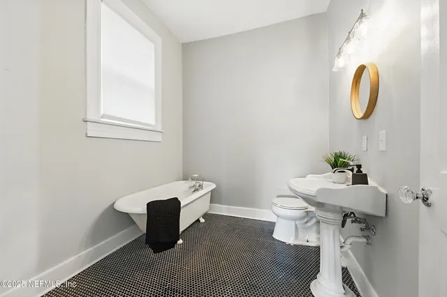 a bathroom with a sink toilet and a mirror