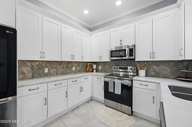 a kitchen with white cabinets and white appliances