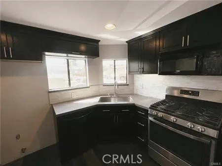 a kitchen with a sink stove top oven and cabinets
