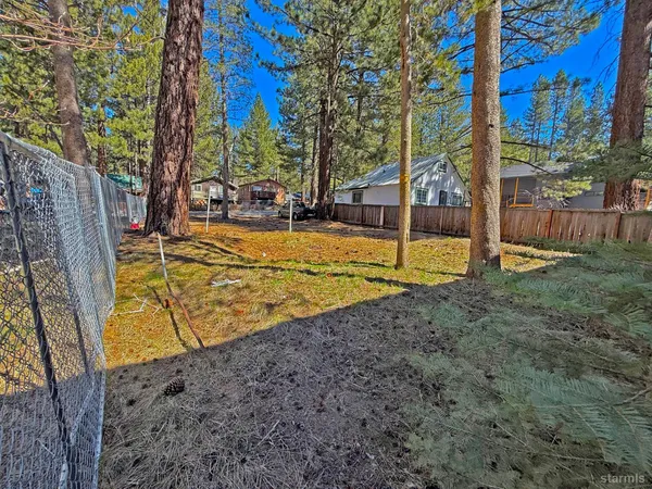 a view of a yard with wooden fence