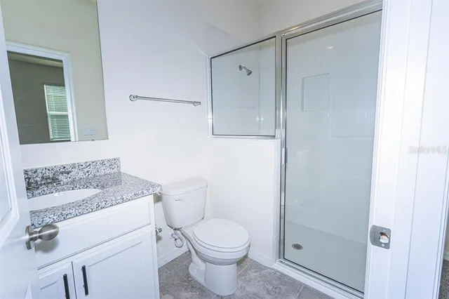 an empty room with a bathroom and a mirror