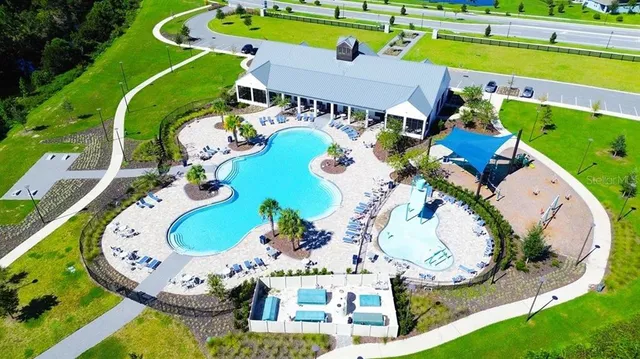 an aerial view of a swimming pool with yard