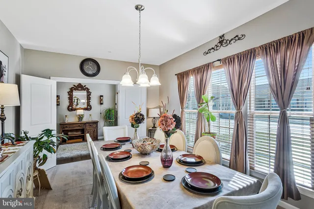 a living room with furniture a chandelier fan and a large window