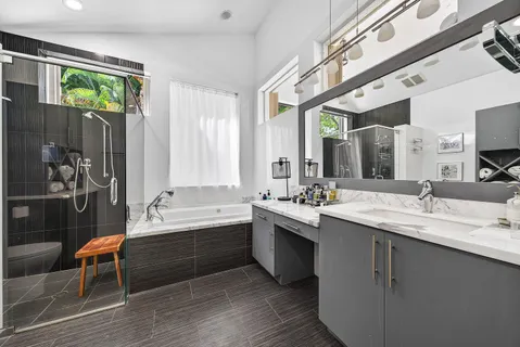 a bathroom with a tub sink and mirror