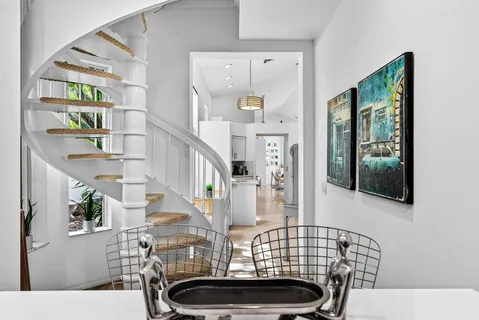 a view of hall way with furniture and chandelier