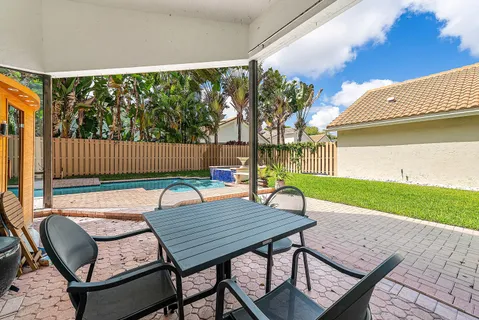 a view of a wooden chairs and table in the patio
