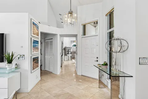 a view of hall way with furniture and chandelier